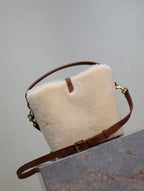 Cream shearling-look YSL bag with brown crossbody strap and gold chain hardware