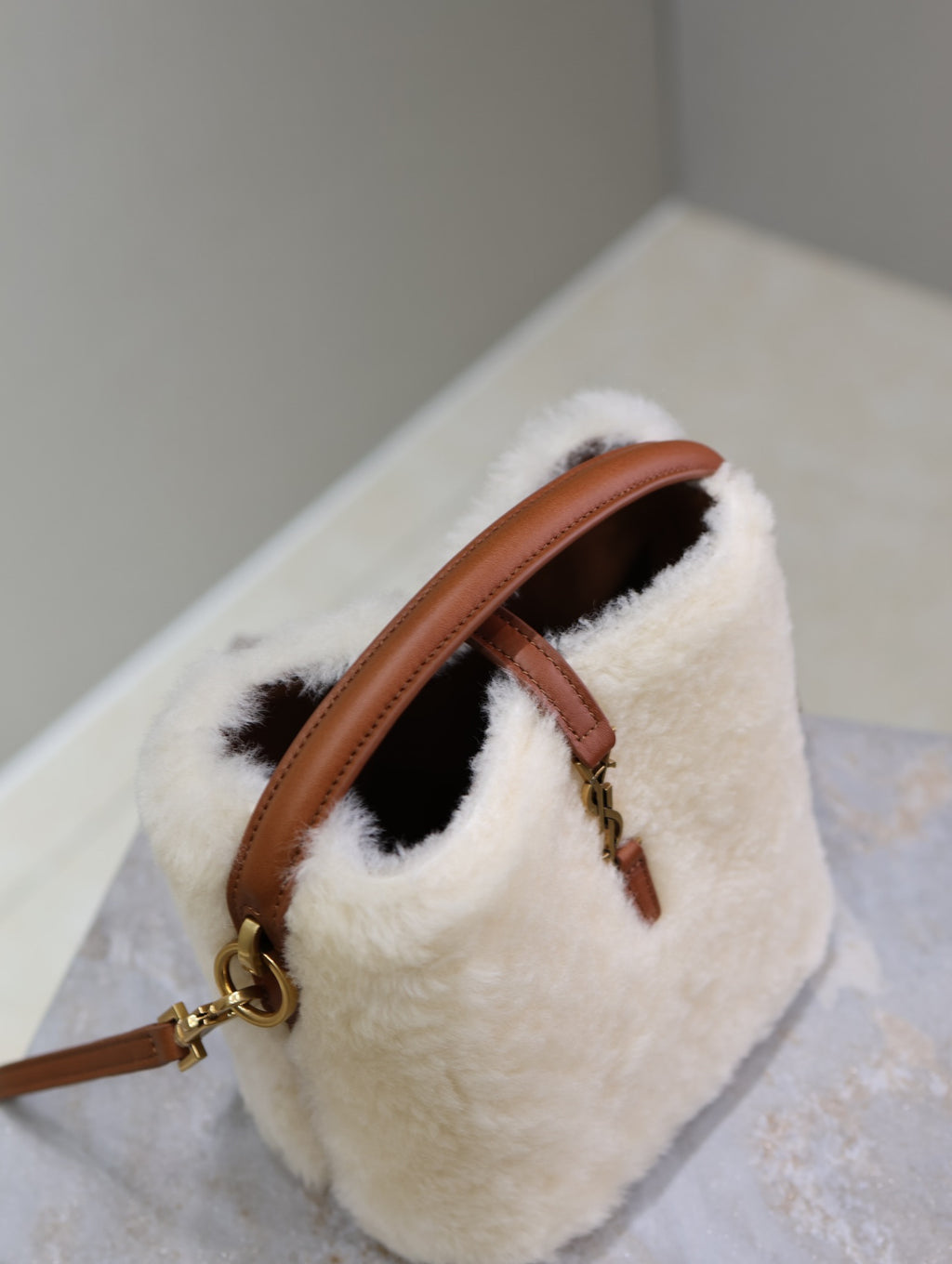YSL faux fur mini bag with open top, brown leather strap, and gold-tone chain