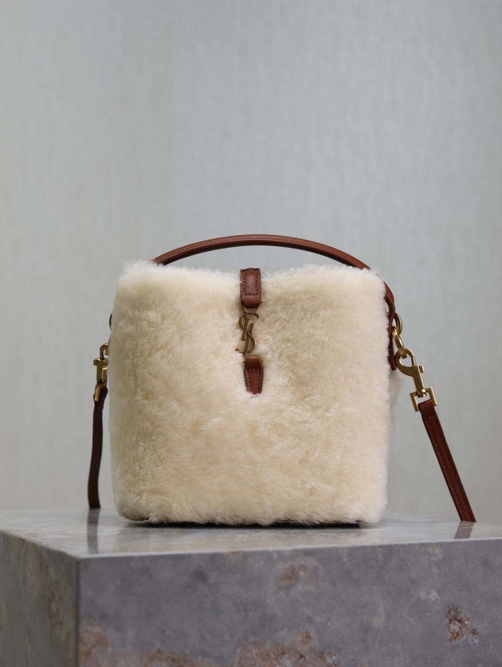 YSL faux fur bucket bag with brown leather top handle and front tab closure