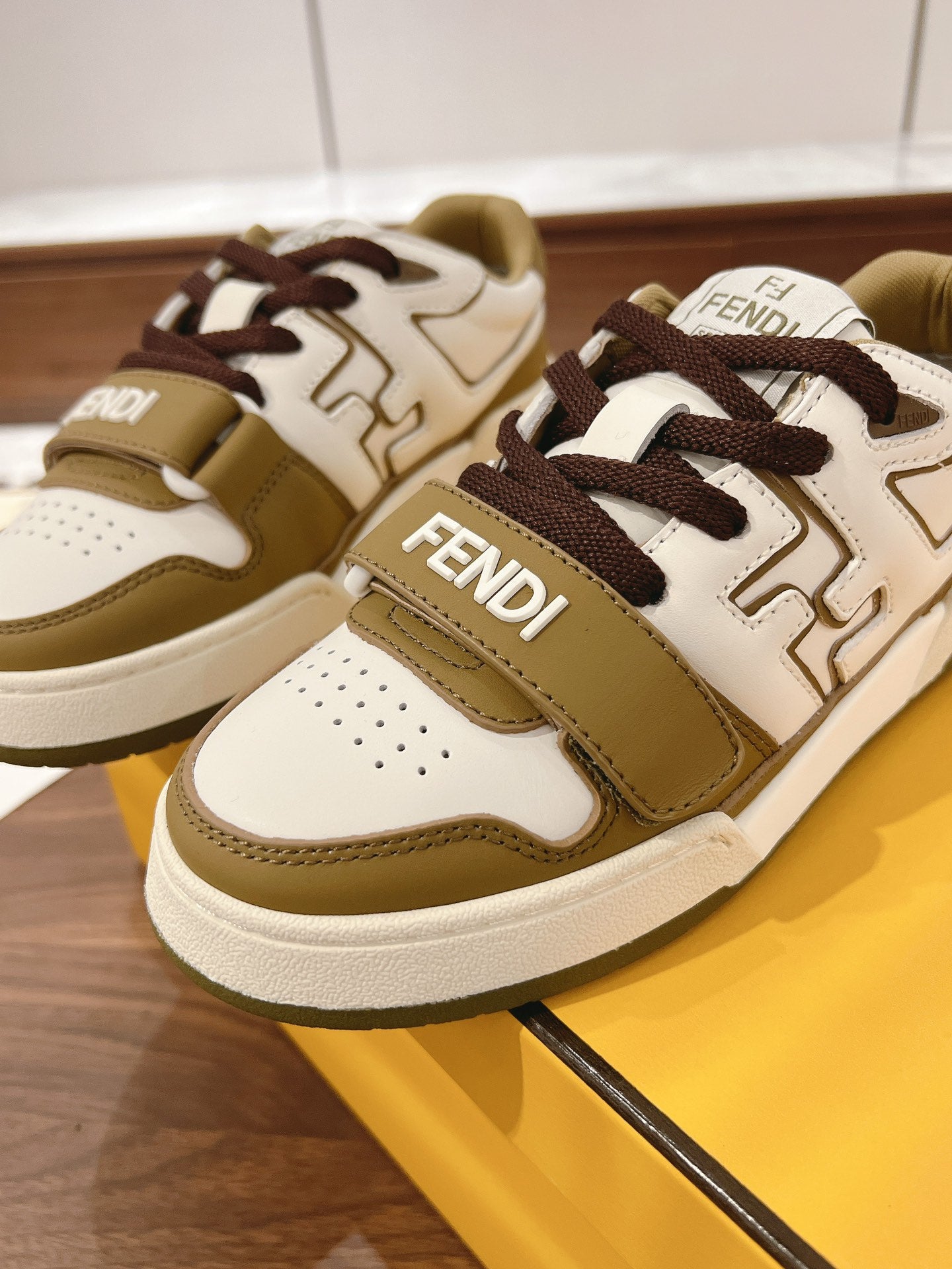 Fendi low-top sneakers front and side view; white with tan panels and dark brown laces