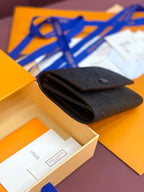 Small dark leather wallet folded with embossed monogram, open view