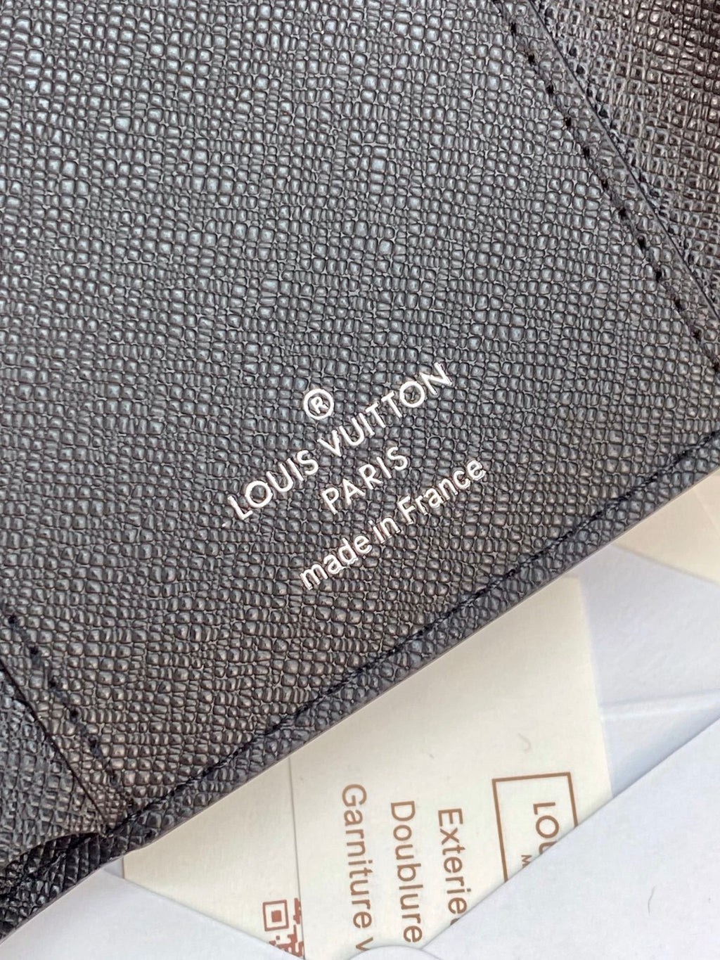 Small bag wallet close-up with “Louis Vuitton Paris” stamped on leather