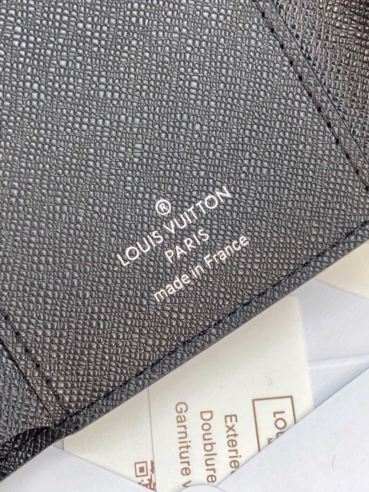 Small bag wallet close-up with “Louis Vuitton Paris” stamped on leather