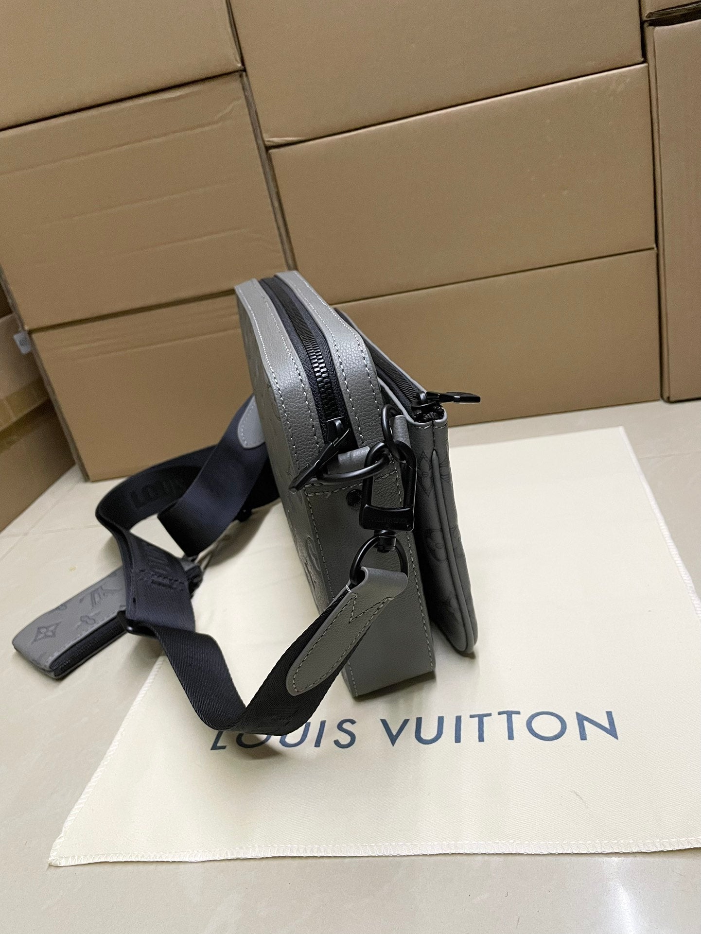 Men's Louis Vuitton crossbody bag, gray monogram, side view with dual shoulder straps