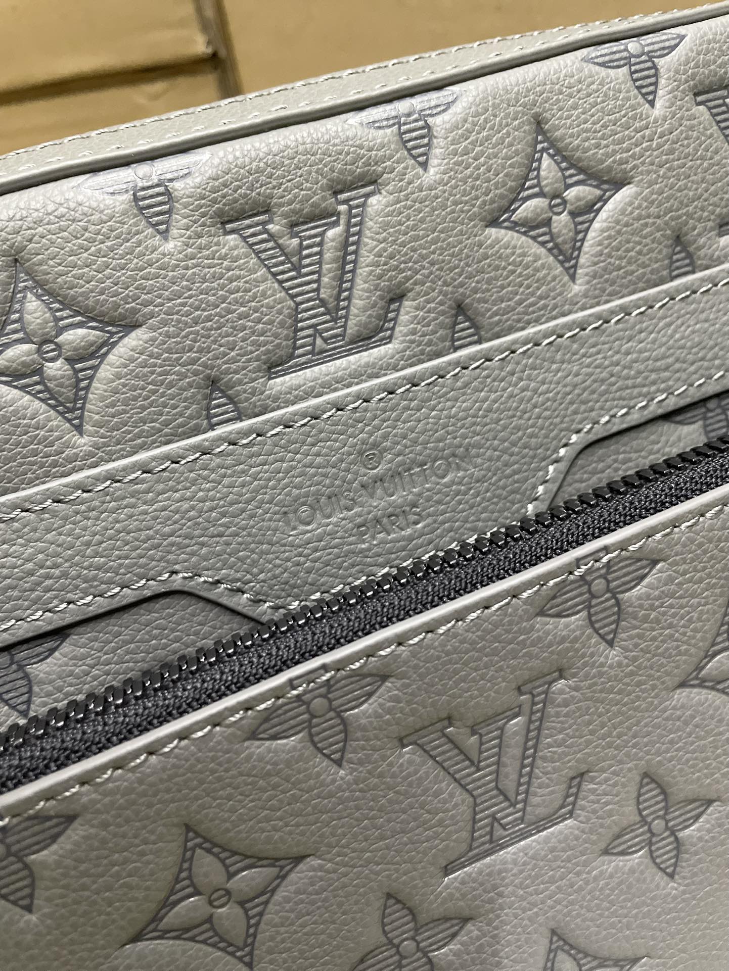 Men's Louis Vuitton gray monogram leather panel close-up with zipper edge