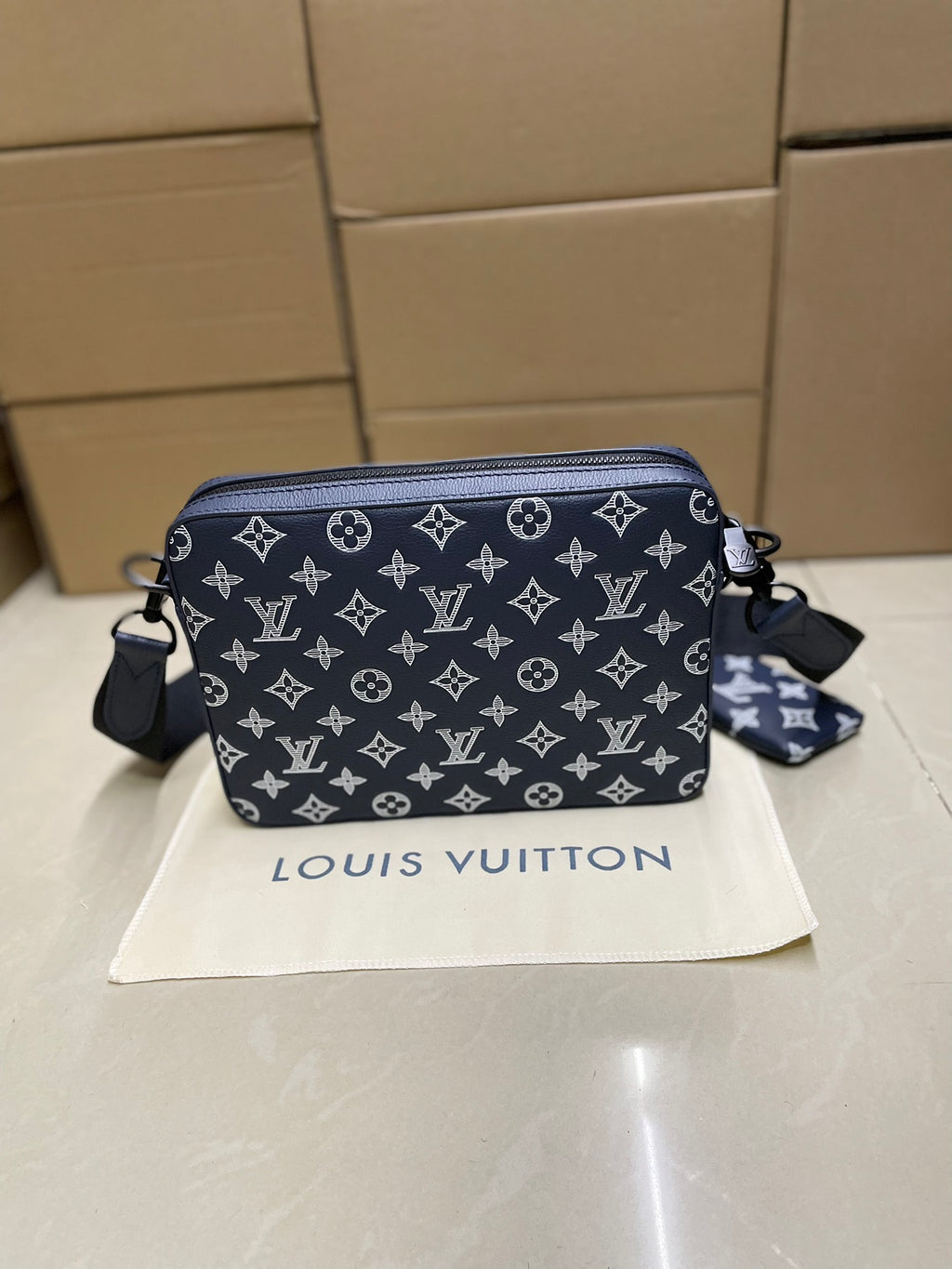 Men's Louis Vuitton crossbody bag, navy monogram pattern with side strap detail.
