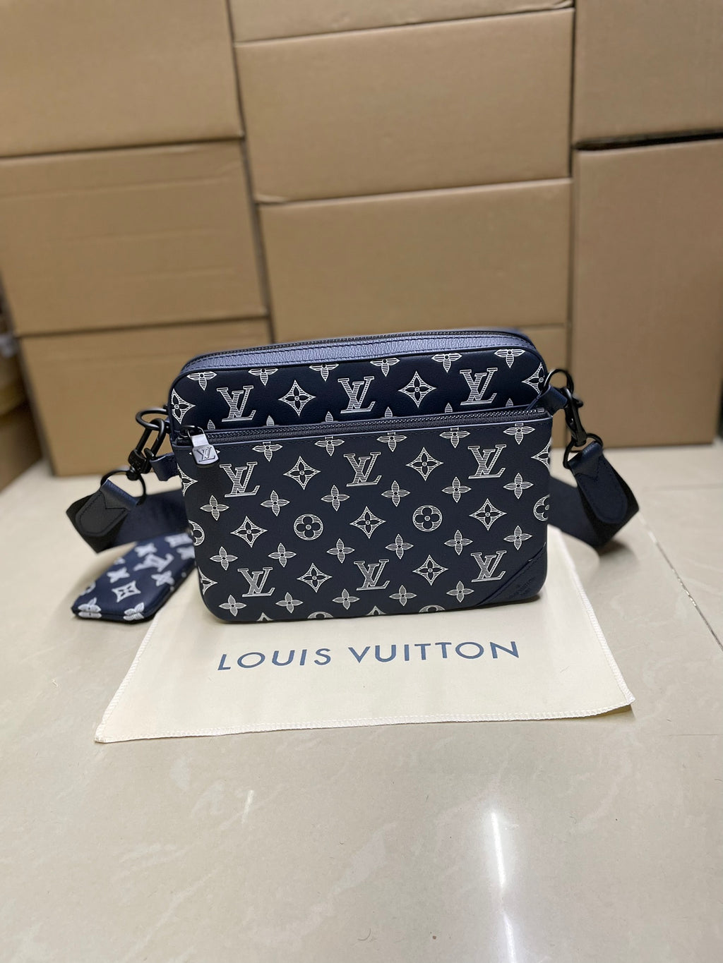 Men's Louis Vuitton crossbody bag, navy monogram with zip top and shoulder strap.