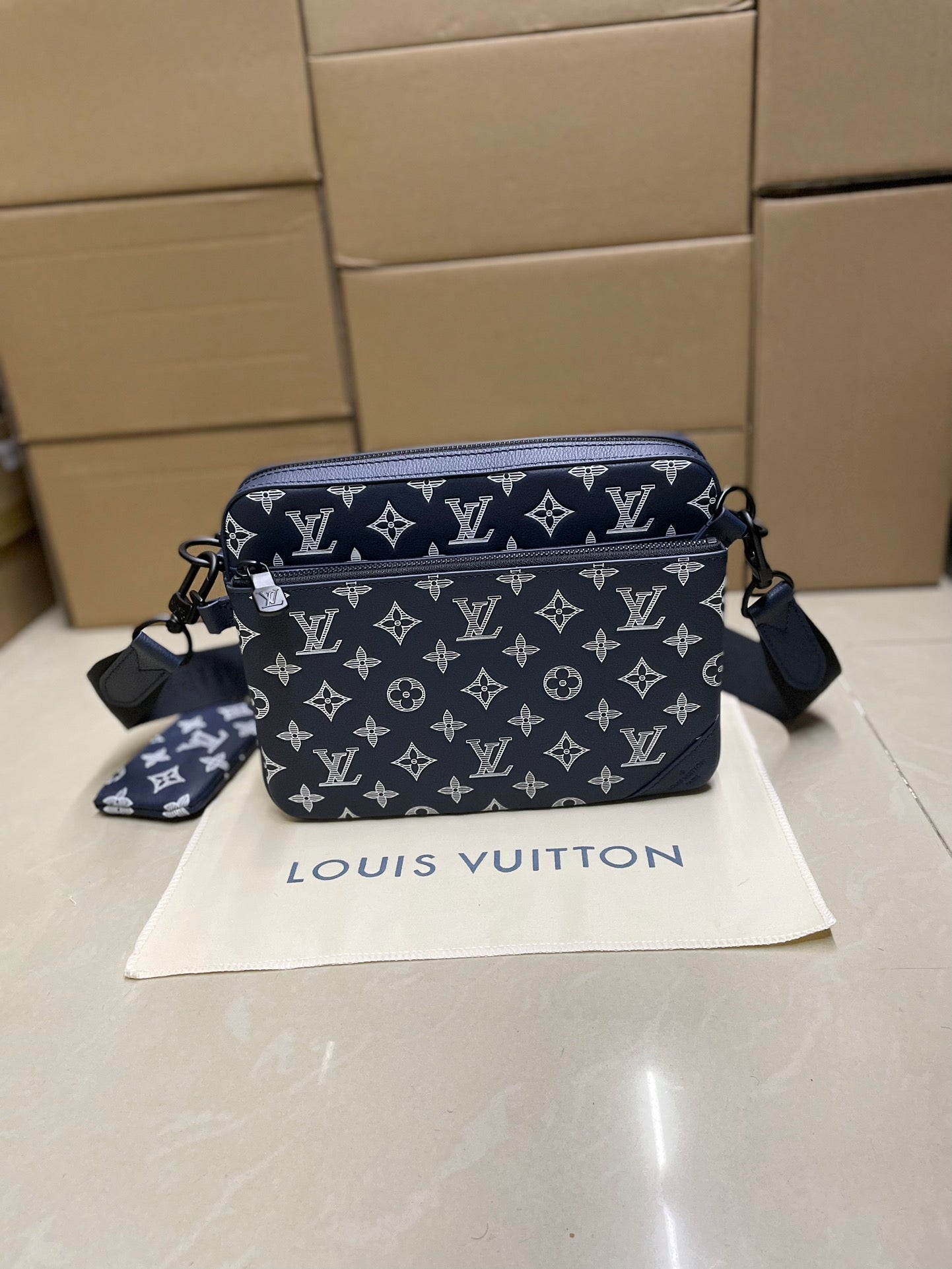 Men's Louis Vuitton crossbody bag, navy monogram with zip top and shoulder strap.