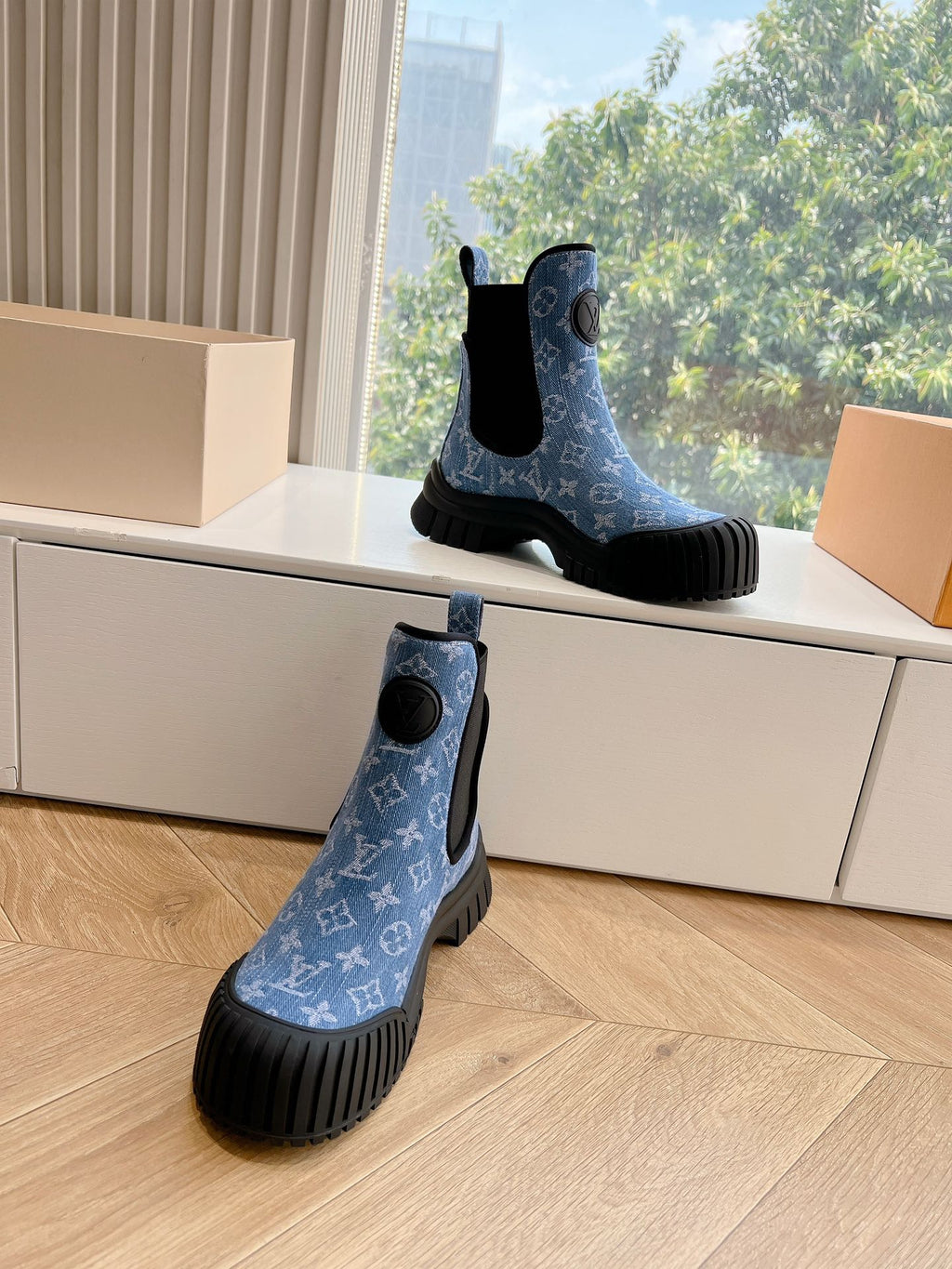 Two blue monogram Chelsea boots with black elastic sides and textured tread rubber soles