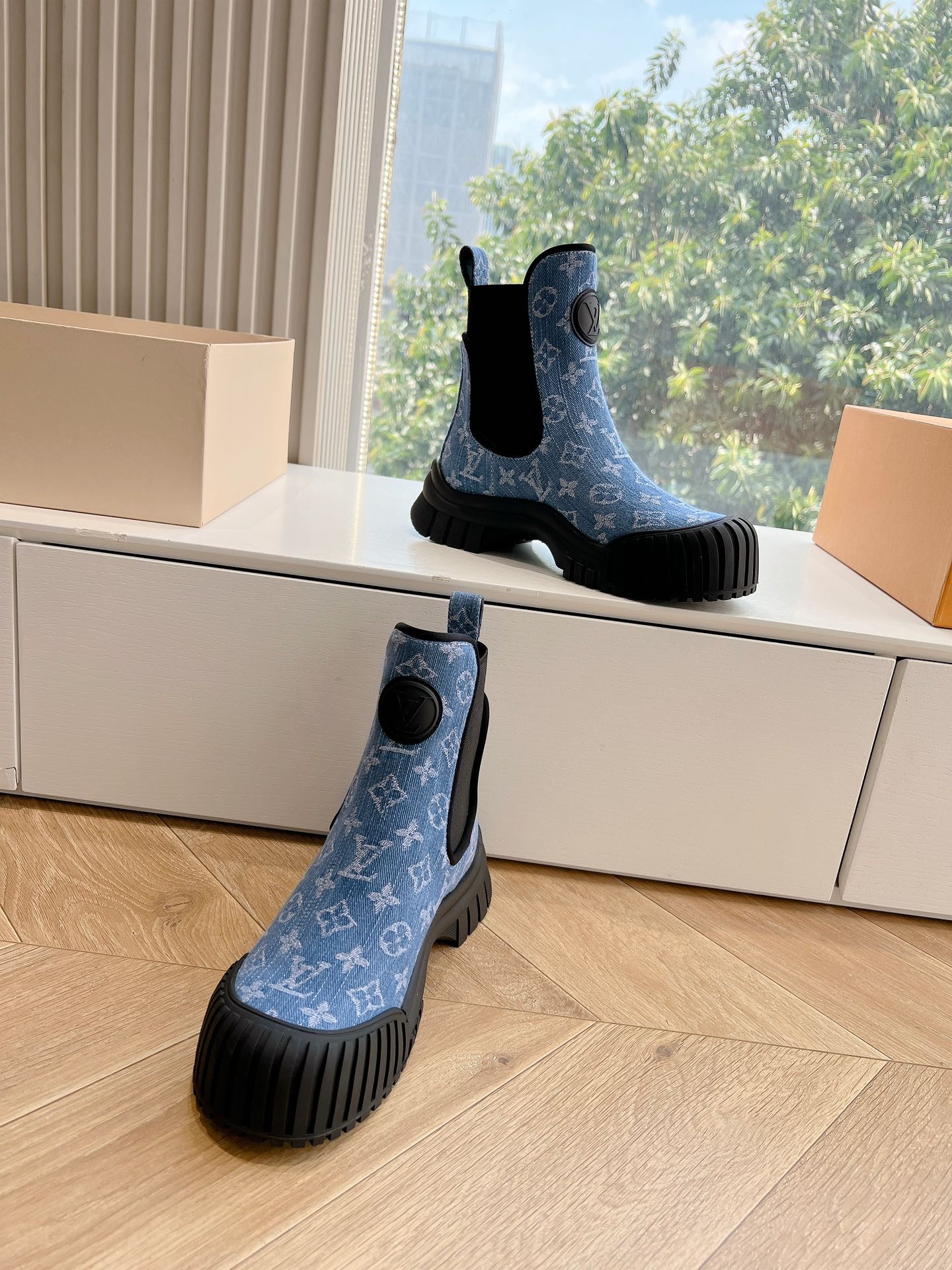Two blue monogram Chelsea boots with black elastic sides and textured tread rubber soles