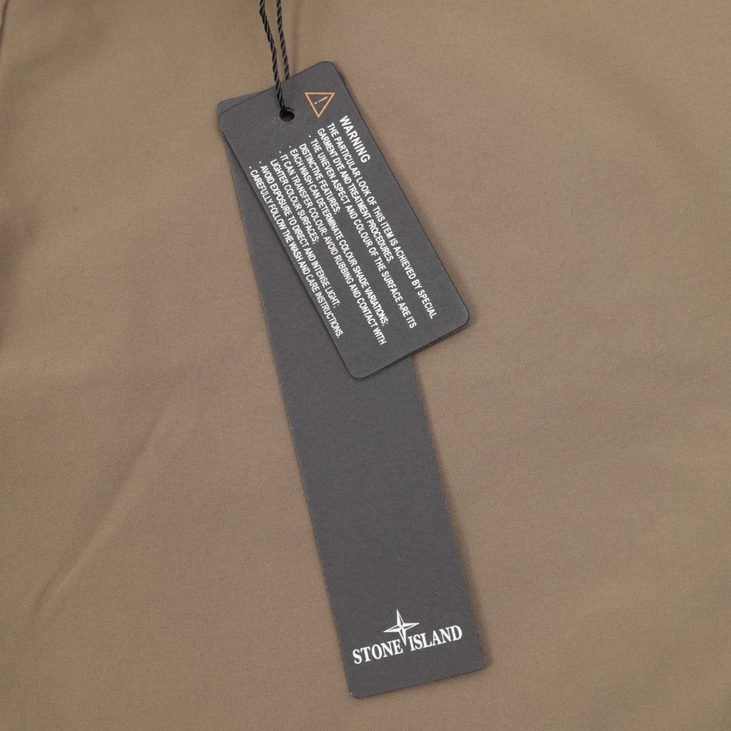 Stone Island garment tag on beige shorts with printed care label
