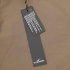 Stone Island garment tag on beige shorts with printed care label
