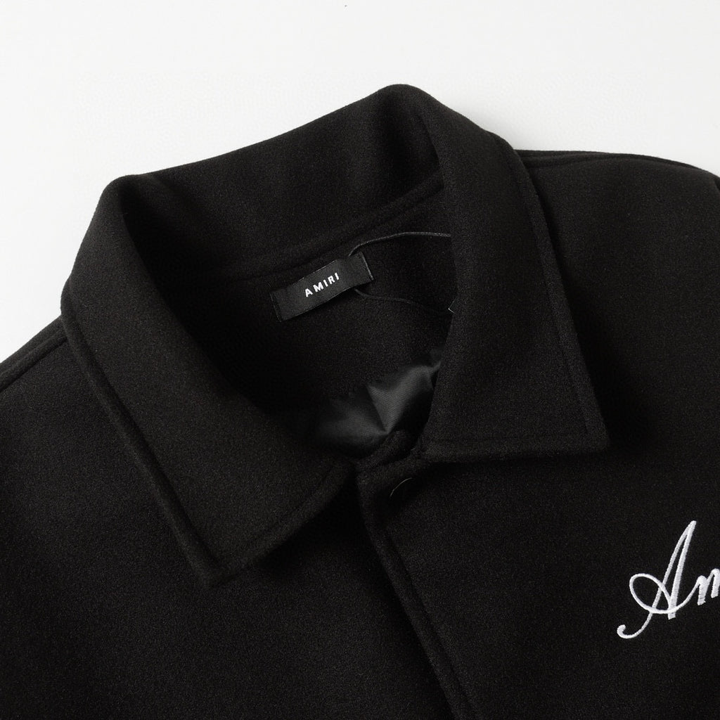 Black jacket lapel with inner label and embroidered Amiri logo