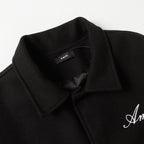 Black jacket lapel with inner label and embroidered Amiri logo