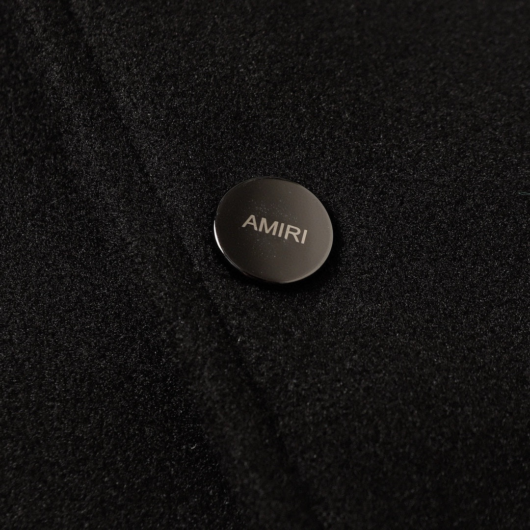 AMIRI logo button on black fabric