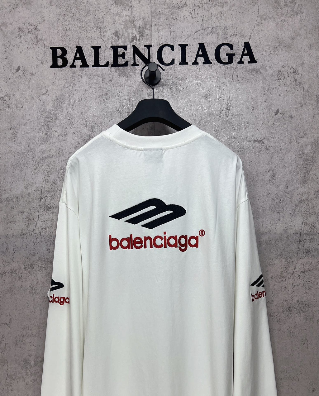 White long-sleeve T-shirt back view with black emblem and red Balenciaga logo