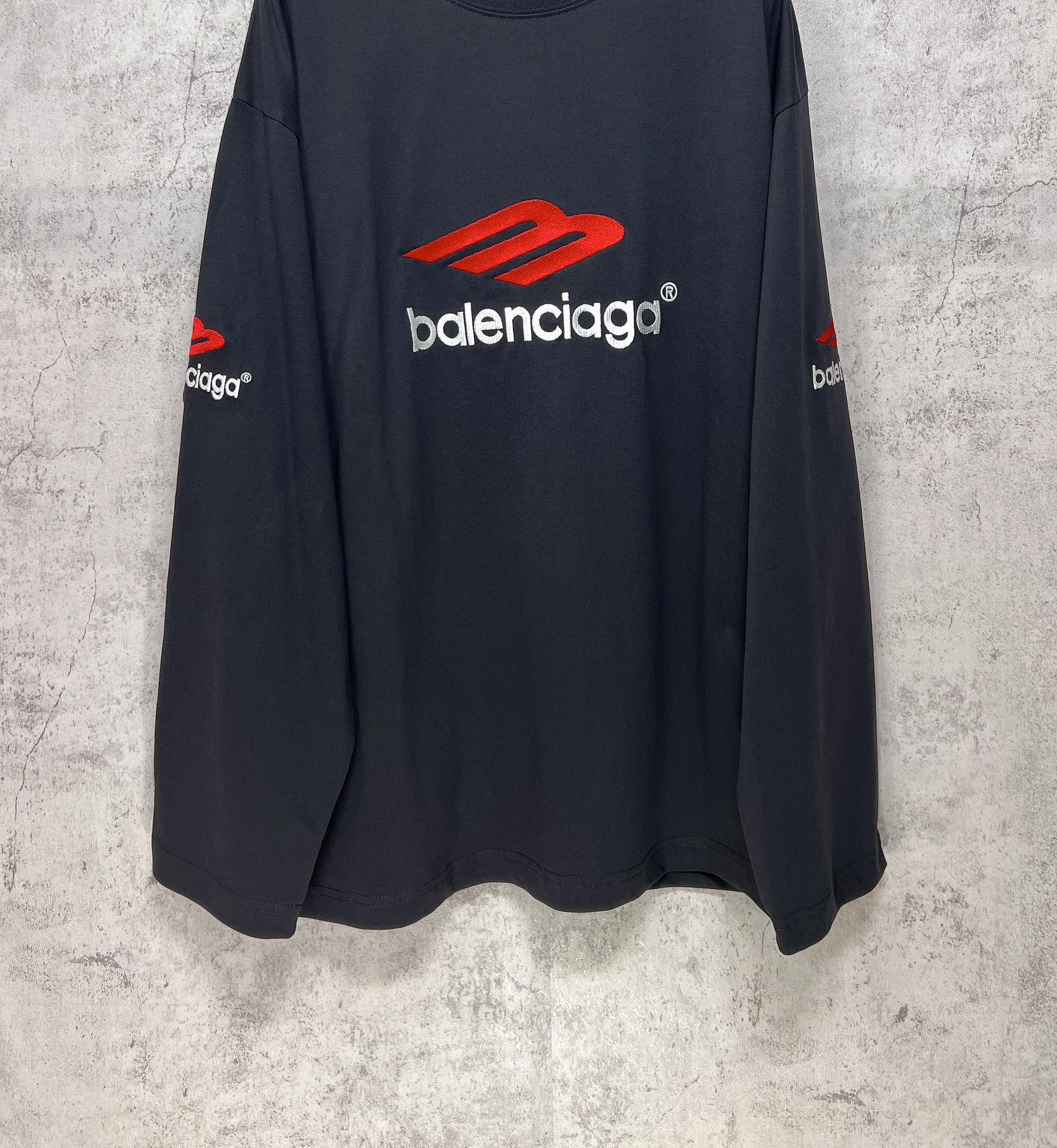 Balenciaga long-sleeve T-shirt, dark navy, side view with red logo on chest and sleeve text