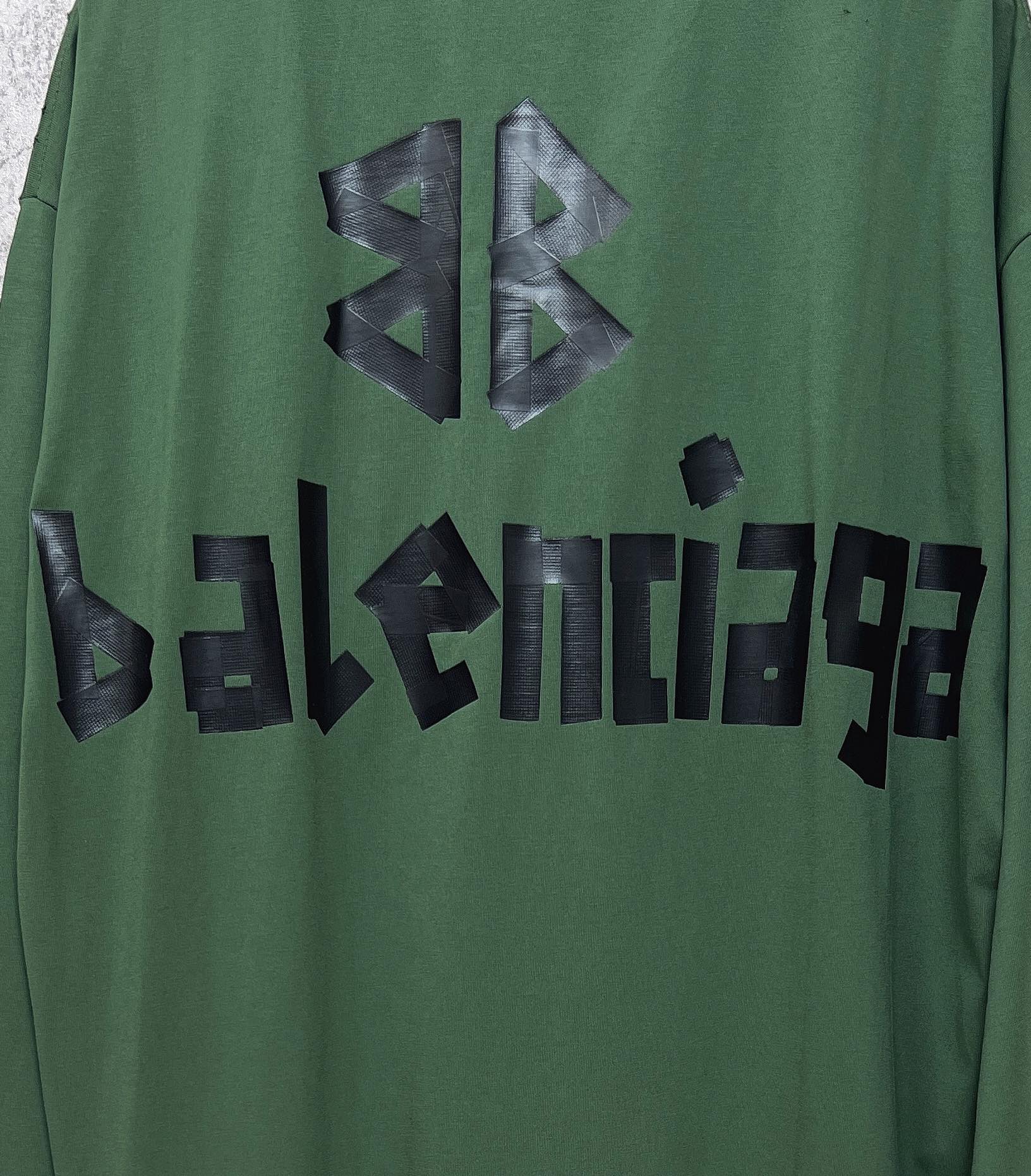 Close-up of green long-sleeve T-shirt with black Balenciaga logo lettering