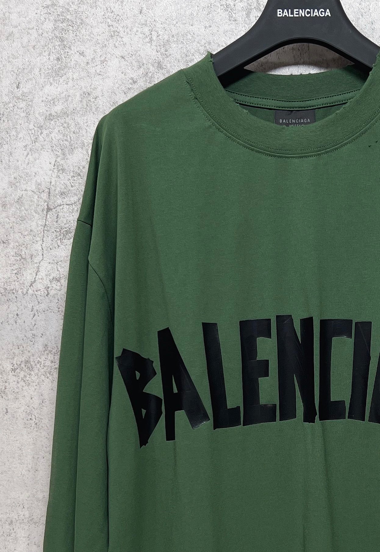 Green long-sleeve T-shirt close-up with black Balenciaga logo print