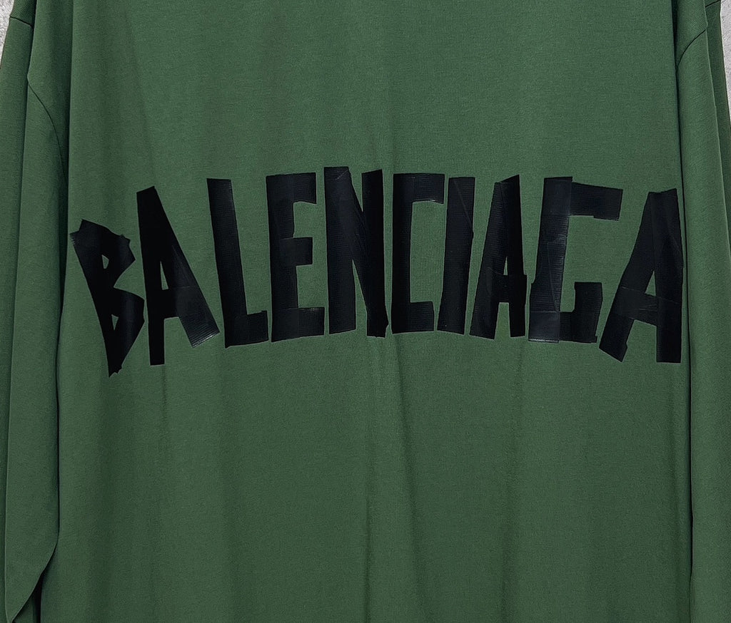 Close-up of green long-sleeve T-shirt with large black Balenciaga logo print