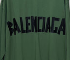 Close-up of green long-sleeve T-shirt with large black Balenciaga logo print