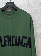 Green long-sleeve T-shirt close-up with black Balenciaga logo on chest