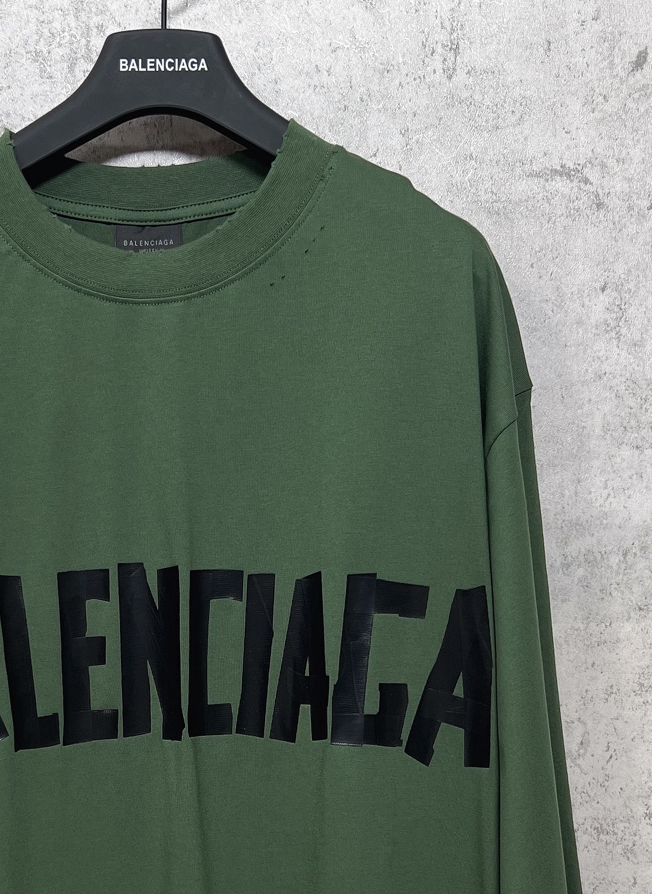 Green long-sleeve T-shirt close-up with black Balenciaga logo on chest