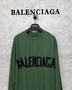 Green long-sleeve T-shirt front view with black Balenciaga logo across the chest
