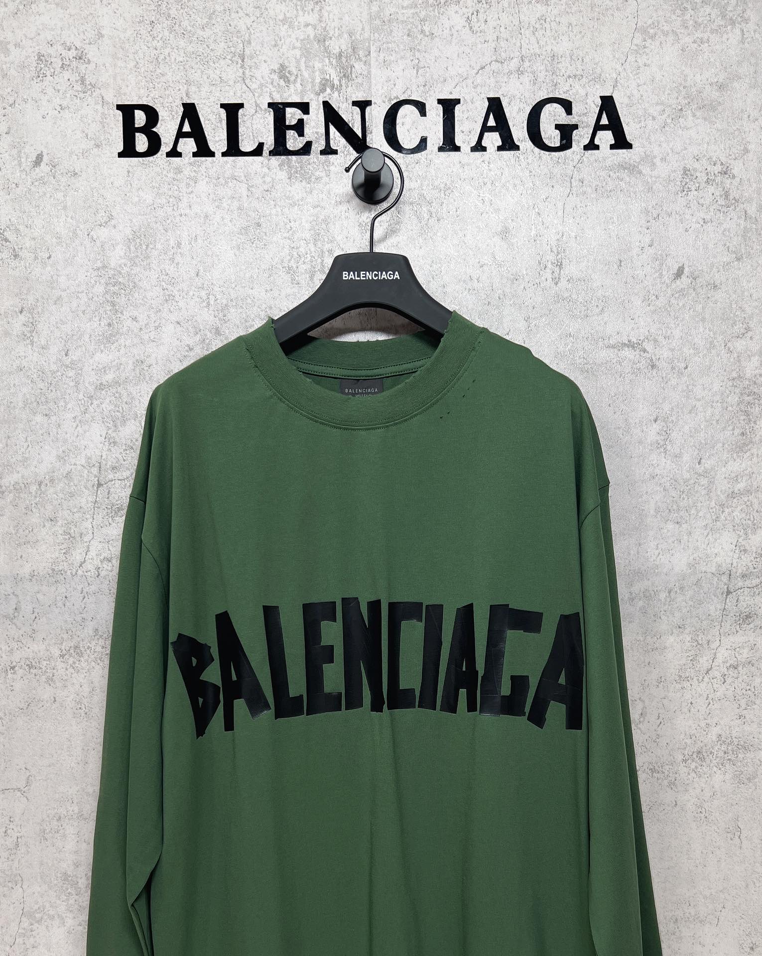 Green long-sleeve T-shirt front view with black Balenciaga logo across the chest