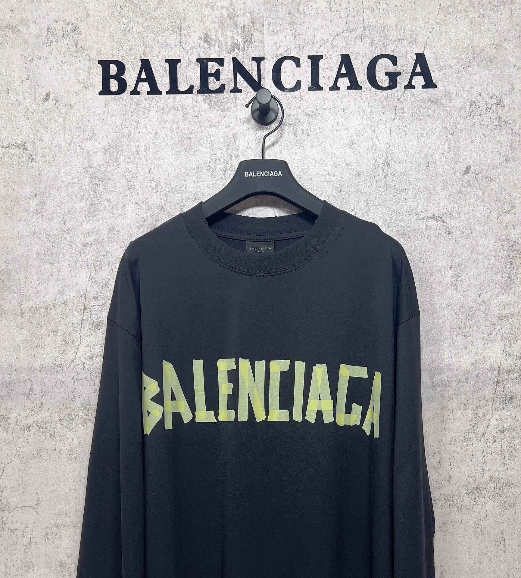 Balenciaga long-sleeve T-shirt with dark body and neon green logo on chest