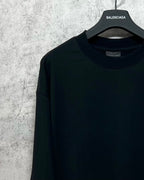 Dark long-sleeve T-shirt close-up at neckline with brand label