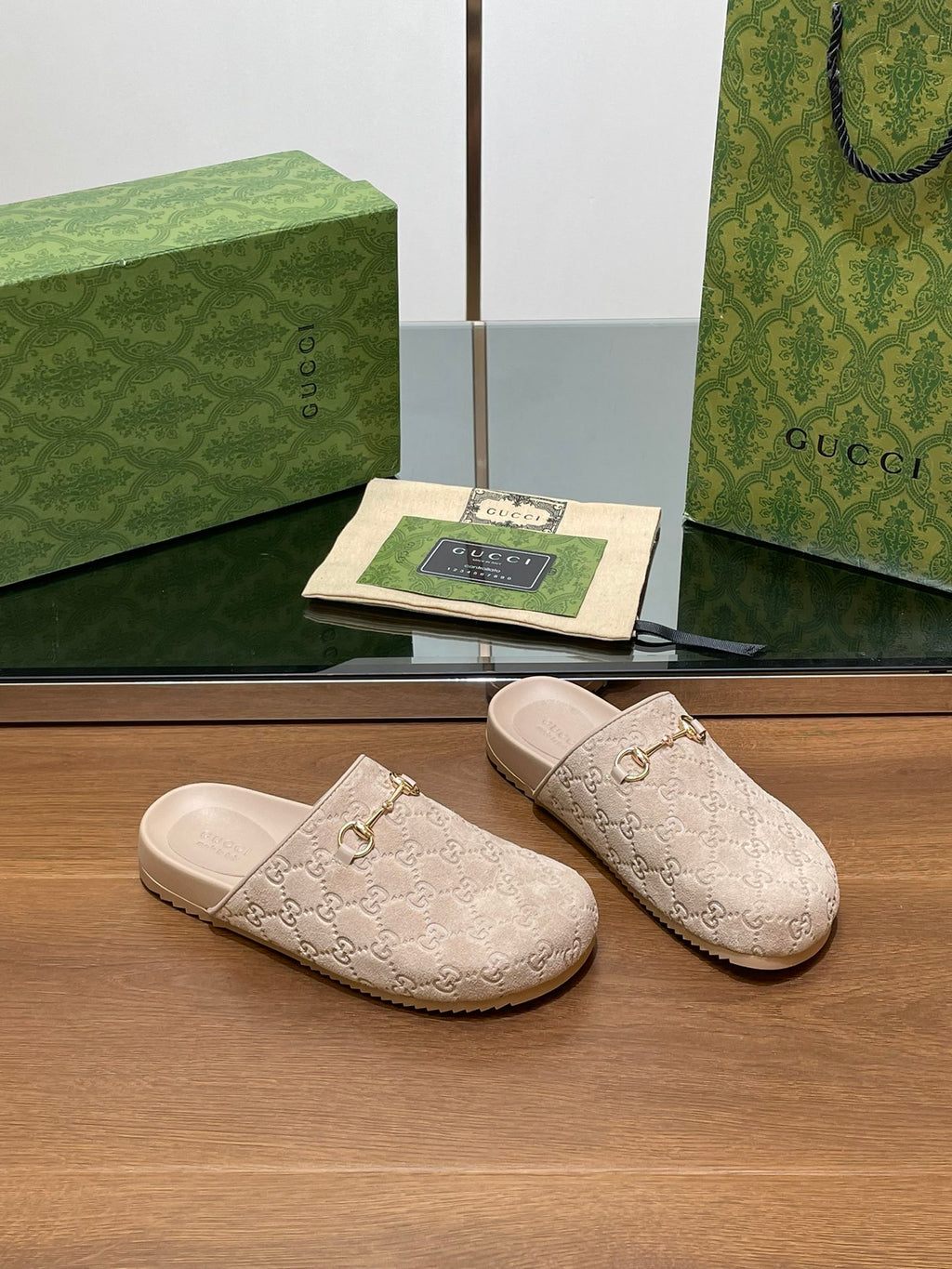 Gucci logo slide sandals in light beige, pair view with gold-tone horsebit hardware