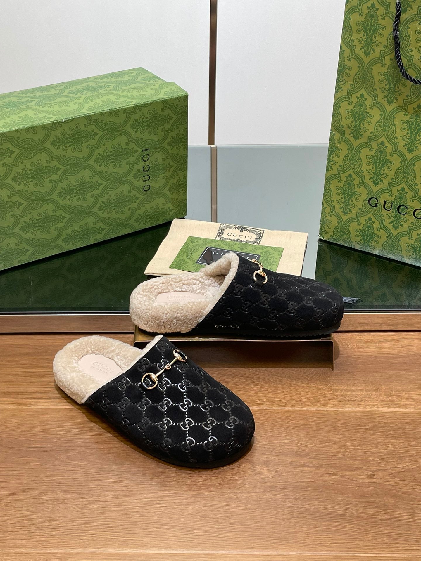 Black monogram mule slippers with beige shearling lining and gold-tone horsebit detail