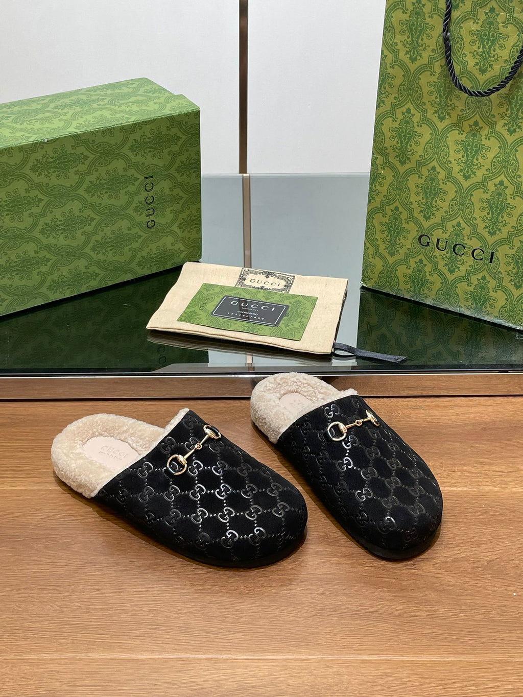 Black monogram mule slippers with beige shearling footbed and gold-tone horsebit charm