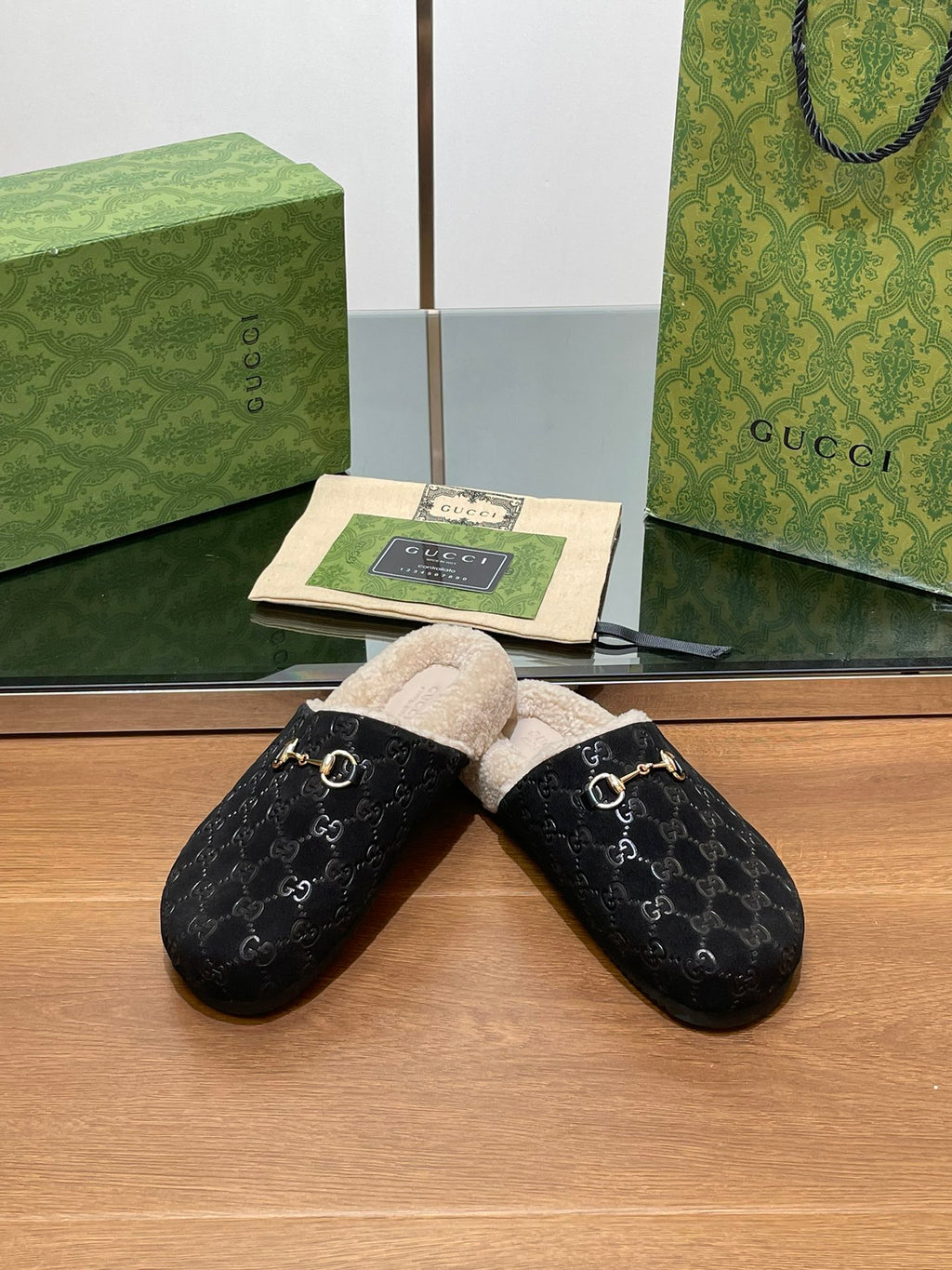 Black monogram mule slippers with beige shearling lining and gold-tone horsebit hardware