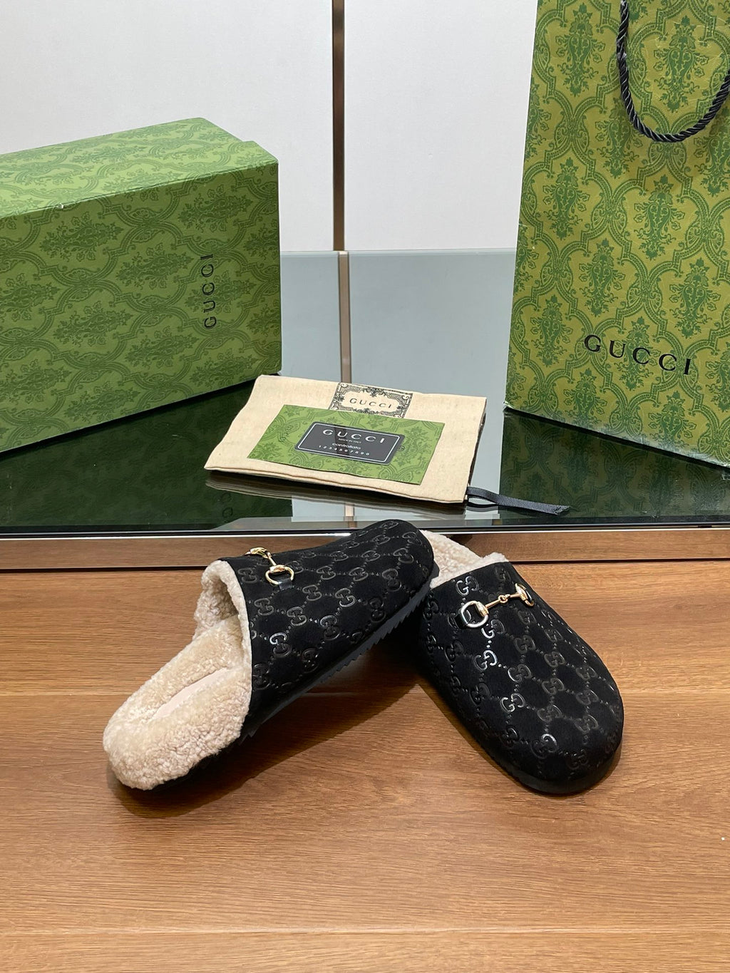 Black monogram mule slippers with beige shearling lining and gold-tone horsebit detail