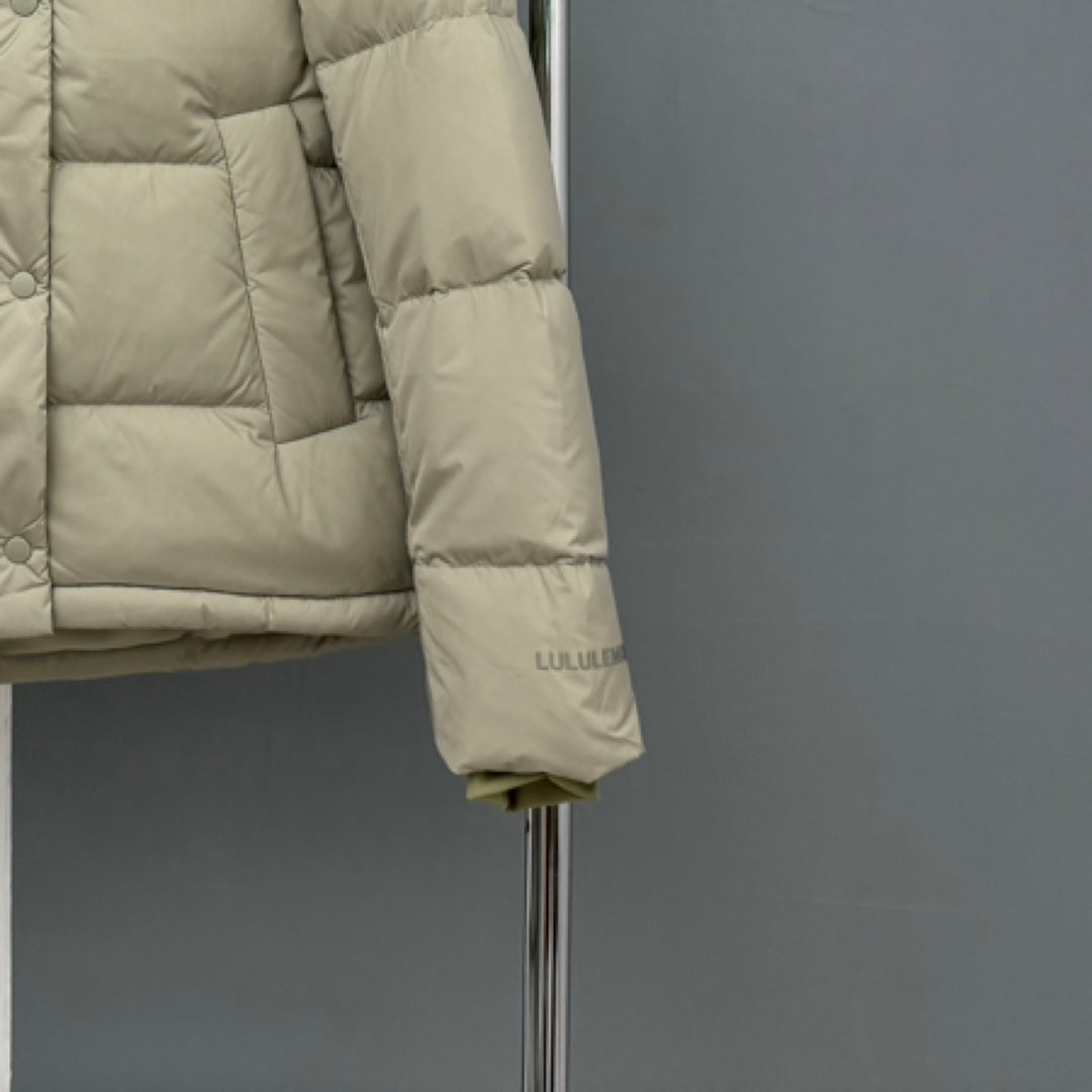 Beige puffer jacket sleeve with small logo embroidery near the hem