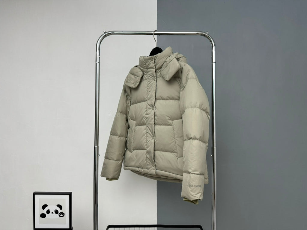 Beige hooded puffer jacket with large hood, front zipper, and button cuffs