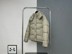 Beige hooded puffer jacket with large hood, front zipper, and button cuffs