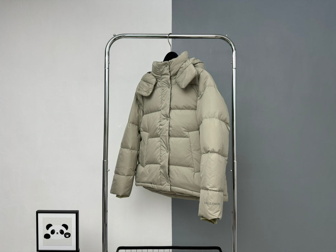 Beige hooded puffer jacket with large hood, front zipper, and button cuffs