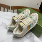 Gucci unisex sneakers, cream with teal panels, gold heel detail, and stripe