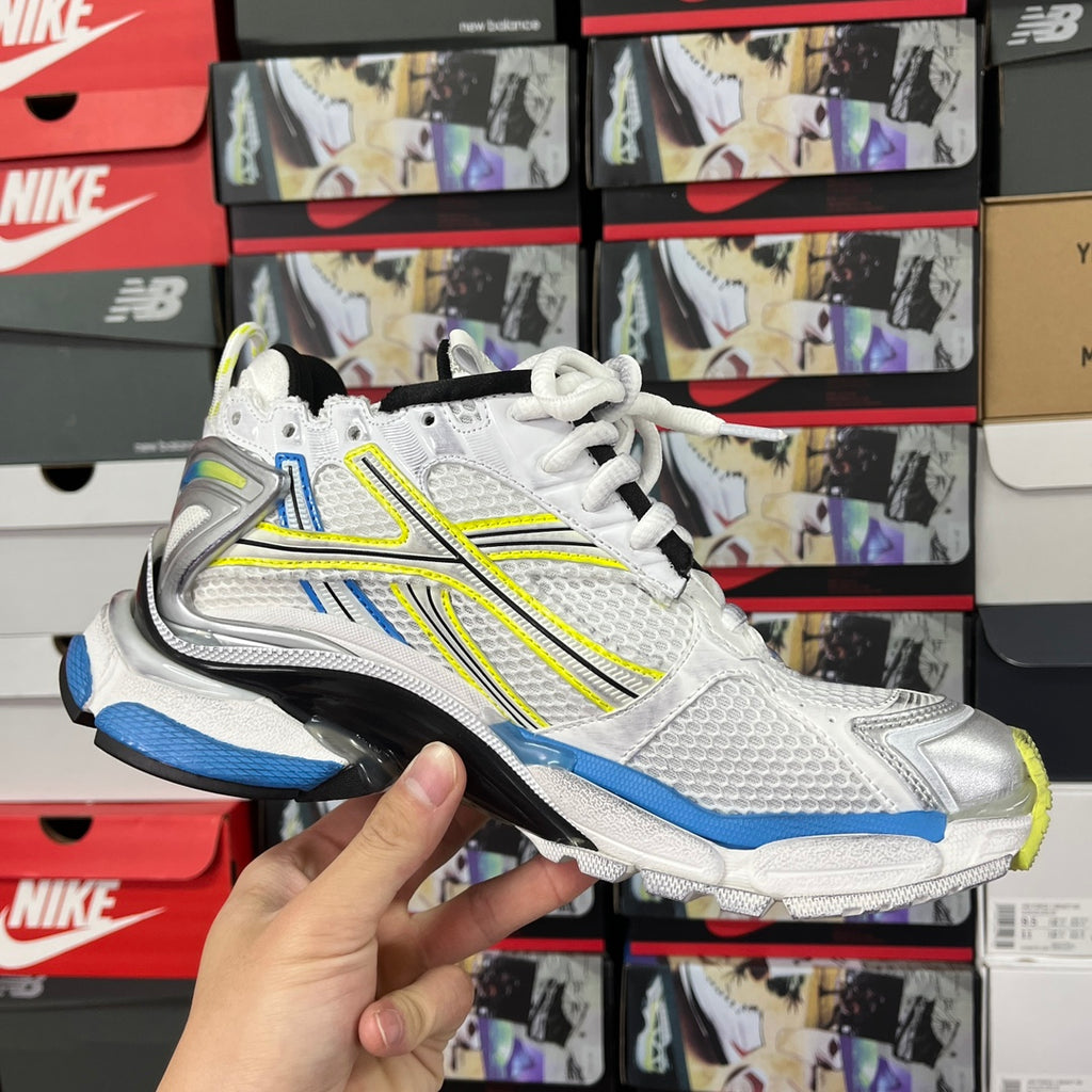 Unisex athletic shoes in white with blue side accents and neon green trim, lace-up