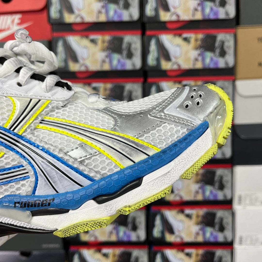 Unisex athletic shoe side profile in white with blue stripe and neon green outsole edge