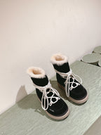 Black high-top lace-up boots with white laces, faux-fur cuffs and beige soles.