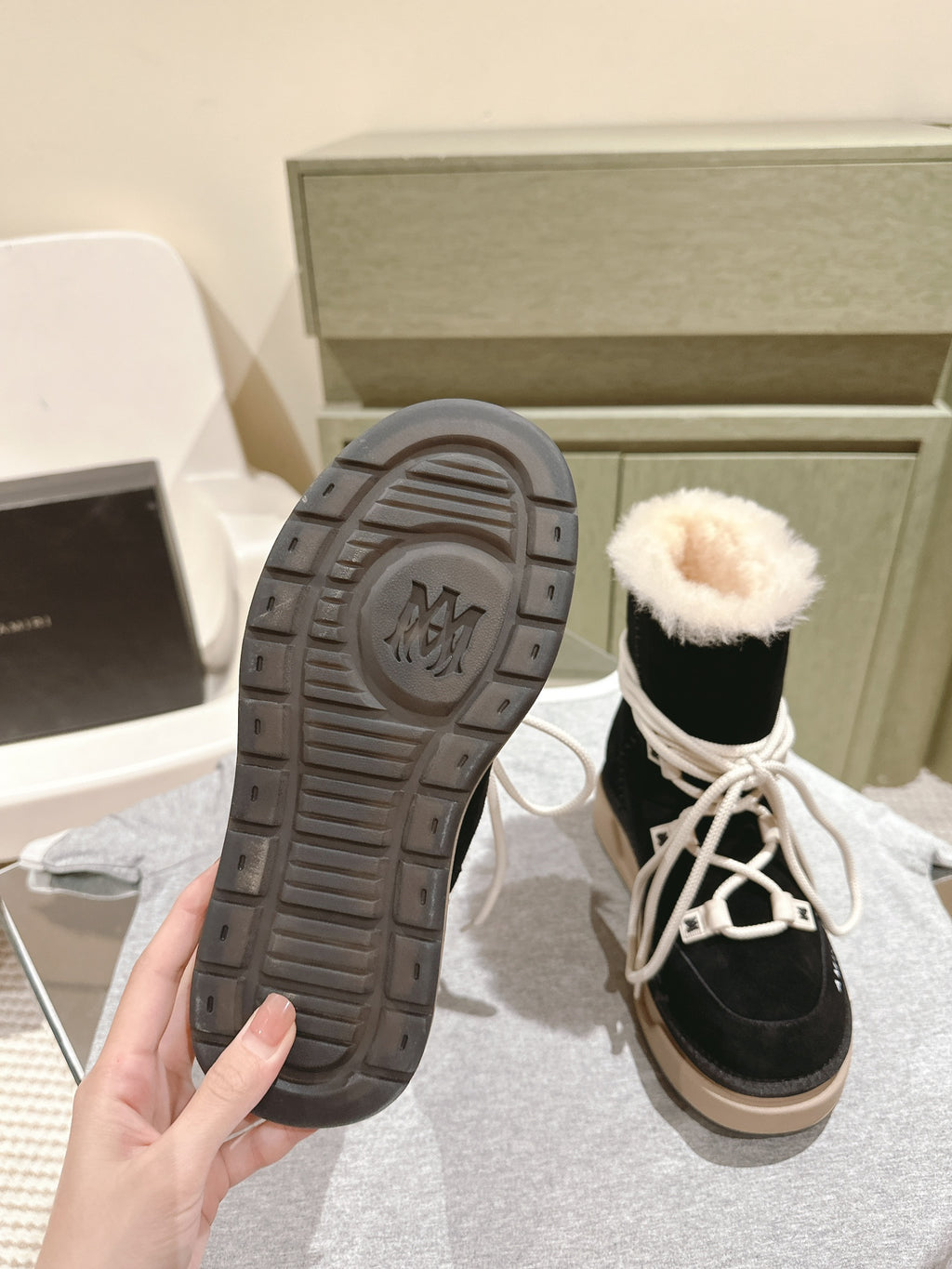 Black high-top boots with faux-fur cuff; textured sole tread shown.