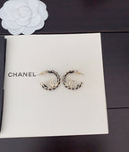 Gold-tone chain hoop earrings with CC logo, laid on card