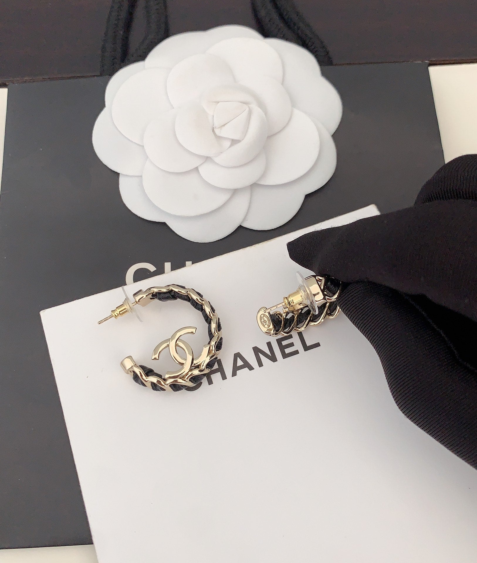 Gold-tone chain hoop earrings with CC logo, close-up on card