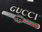 Black T-shirt with Gucci wordmark and multicolor striped logo graphic