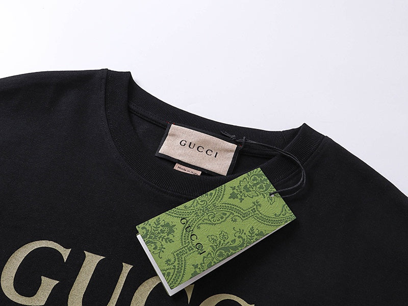 Black T-shirt neckline with Gucci neck label and partial logo graphic