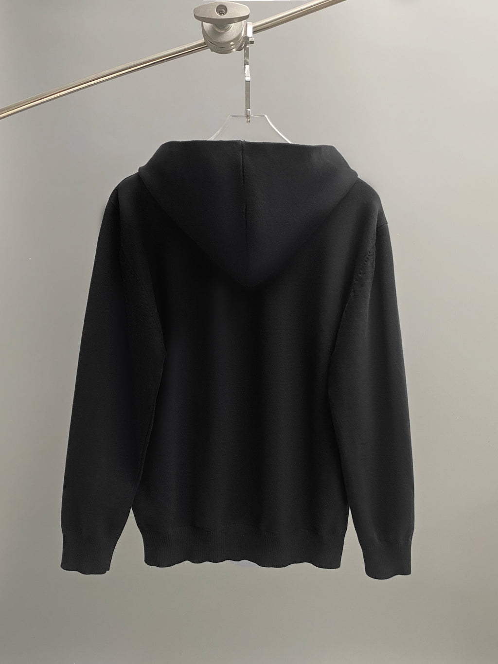 Black hoodie back view with hood and long sleeves.
